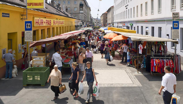 Lively Vienna street market with fresh produce stalls and historic buildings